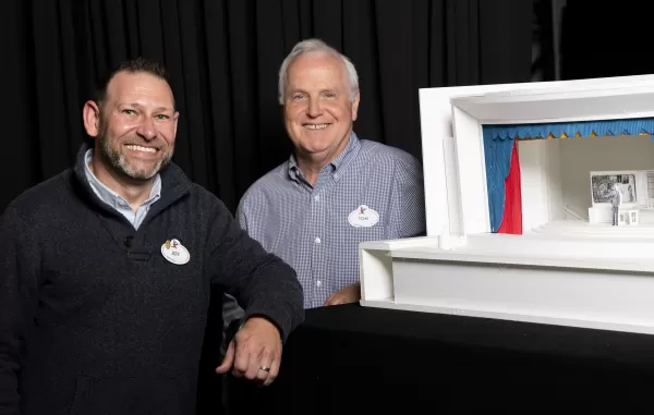 Imagineers da Disney com modelo de palco para a experiência de Walt Disney